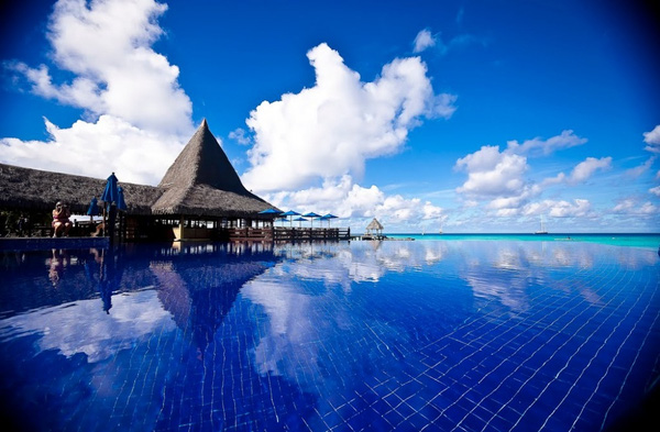 Tại khách sạn The Kia Ora, Rangiroa, Polynesia, bể bơi, biển xanh và mây trời như hoà làm một vậy.